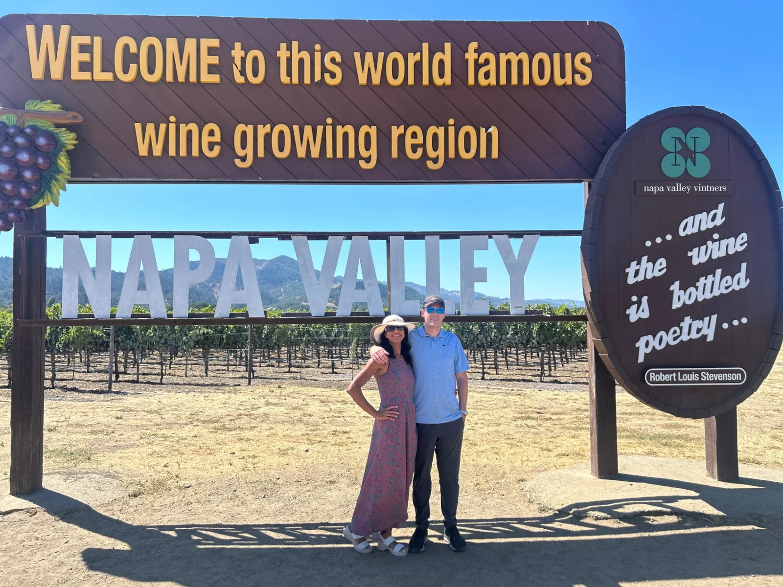 A couple at the Napa Valley welcome sign.
