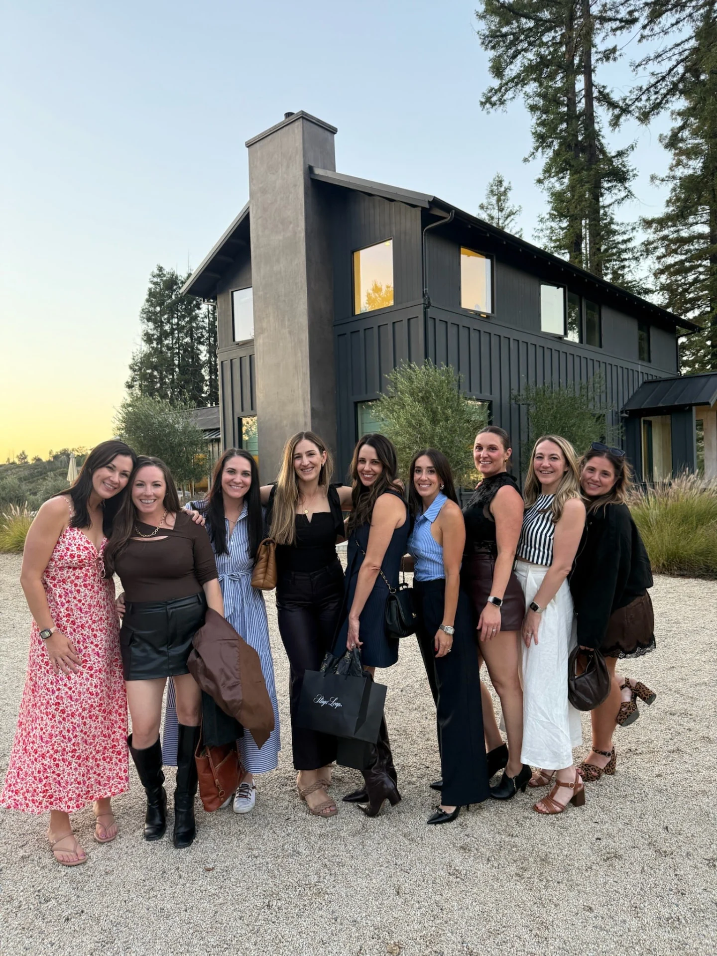 Eleven women posing outside a winery.