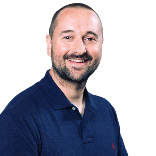 Professional headshot of owner in navy polo shirt with Ralph Lauren logo, smiling warmly at camera against white background